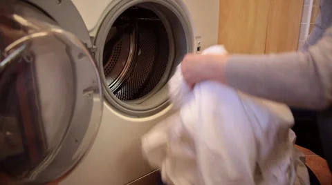 Woman’s hands loading laundry into a washing machine Video stock 65111428