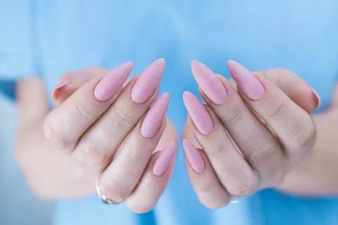 Woman's hands with long nails and a light pink color Stock Photos