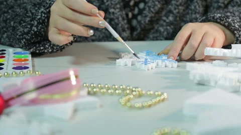Woman's hands make home decorations for Christmas by painting white blanks with Stock Footage 139108746