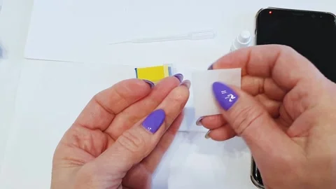 The woman's hands make a puncture of the finger and draw blood into the pipette. Stock Footage 146751497