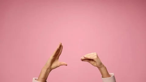 Woman's hands making a gossip gesture, talking and moving on pink background Stock Footage 141922071