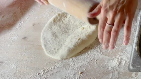 Woman's hands making a khachapuri base using rolling pin on the flour covered ho Stock-Footage 233967775