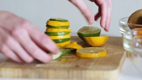 Woman's hands making lemon and lime pyramid in kitchen Video stock 70964430
