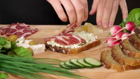 Woman's hands making sandwich  with feta cheese and ham on wooden board Stock Footage