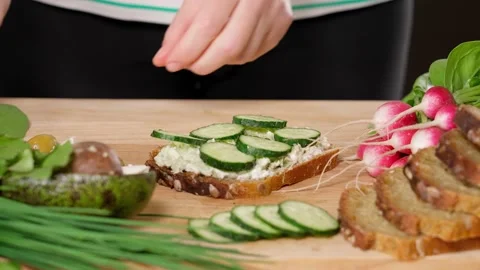 Woman's hands making veggie sandwich on wooden board, close-up Stock Footage 155432986