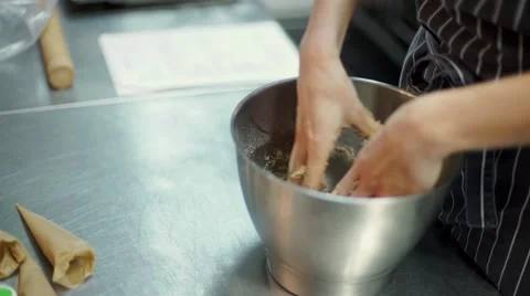The woman's hands is mixing the dough at the kitchen table Stock Footage 57496768