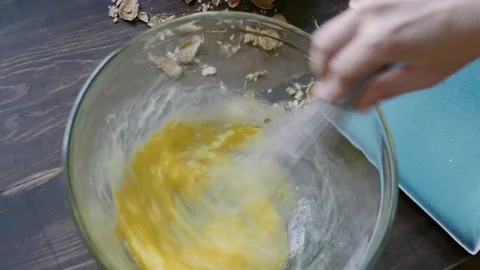 Woman's hands mixing three eggs in a bowl Vídeos de archivo 75759581