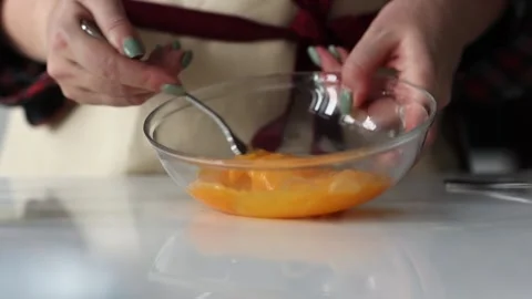 Woman's hands mixing two eggs in transparent plate. Slow motion Stock Footage 231794428