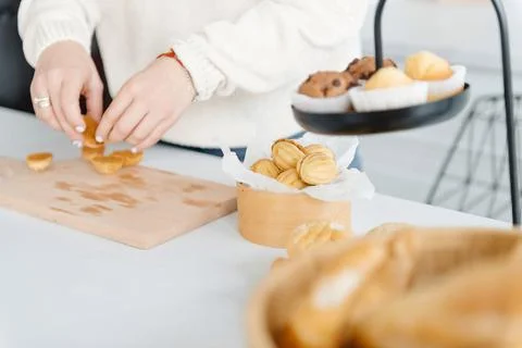 A woman's hands in the modern kitchen make a dessert in the shape of a walnut Photos