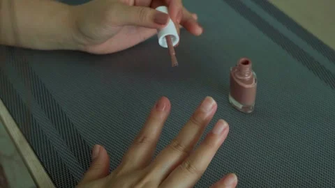 Woman's hands with nail polish on table at home, moment of relaxation Stock Footage 248334202