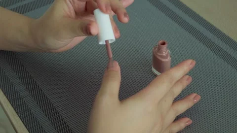 Woman's hands with nail polish on table at home, moment of relaxation Stock Footage 248334223