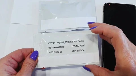 The woman's hands open the package with the Covid19 test and a set of tools. Stock Footage 146751503