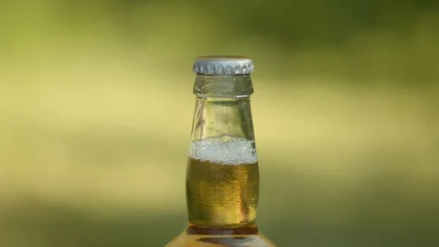 Woman's hands opening beer bottle close up in slow motion with smoke, 4k Stock Footage 112763580