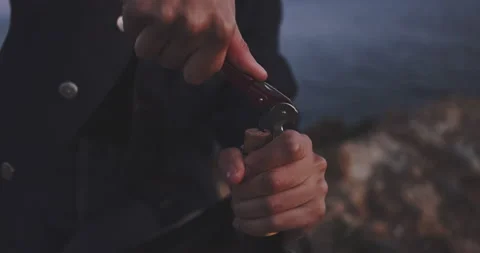Woman's hands opening a bottle of wine by the sea Video stock 203588619