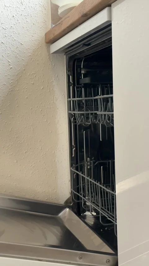 Woman's hands opening an empty dishwasher in a modern kitchen, pulling out .. Stock Footage 331884282