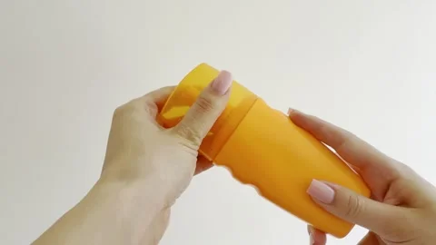 Woman's hands opening an orange sunscreen spray bottle for skin care, sunba.. Stock Footage 335139643