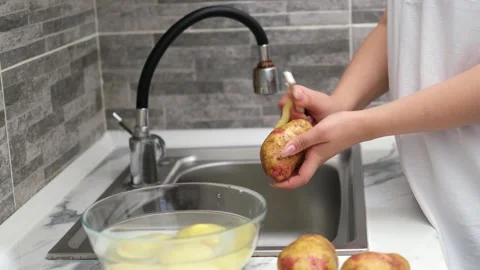 Woman's hands peeling potatoes close up Stock Footage 289388657