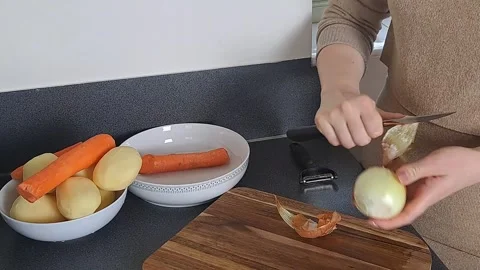 Woman's hands peeling raw onions in kitchen, dinner cooking Stock Footage 241935313