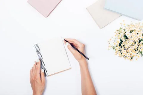 Woman's hands with pencil making notes on blank sheet Stock Photos