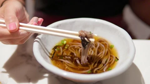 Woman's hands picking up Toshikoshi Soba Japanese buckwheat noodle with Stock Footage 212376814