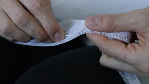 Woman's hands with a pin stab the transparent fabric Stock Footage 180383719