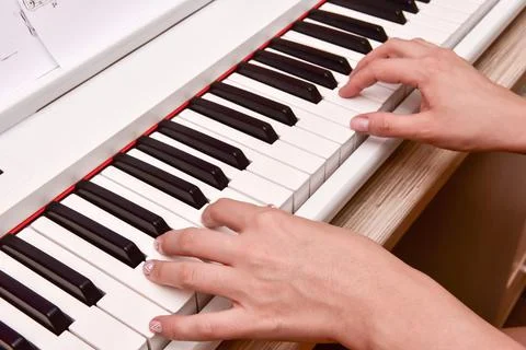 Woman's hands playing electronic digital piano at home. The woman is professi Stock Photos