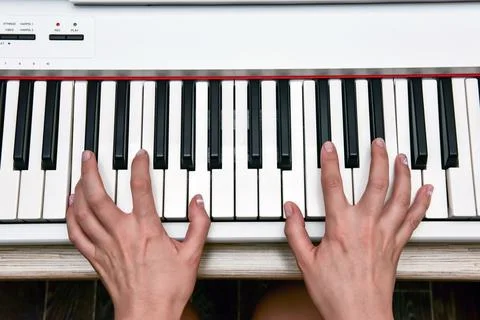 Woman's hands playing electronic digital piano at home. The woman is professi Stock Photos