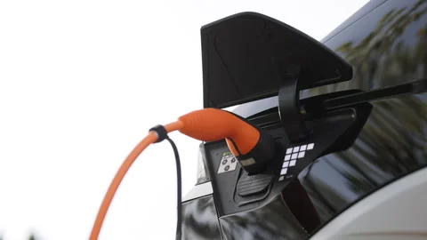 Woman's hands plugging her electric automobile. Female hand inserts an erectile Stock Footage 272309806