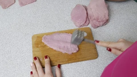 Womans Hands Pounding Raw Meat with a Metal Tenderizer Stock Footage 330298522