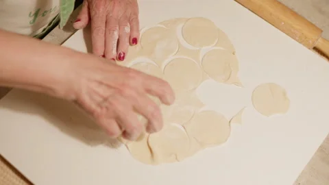 Woman’s hands preparing pelmeni dumplings with rolling pin on flour-dusted kitch Video stock 319373530