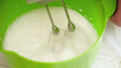 Woman's hands prepering the cream for the eclairs with mixer Stock Footage 74477454