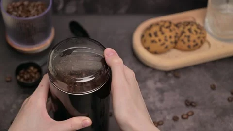 Woman's hands press the button on the coffee grinder and the coffee is ground Stock Footage 321091168