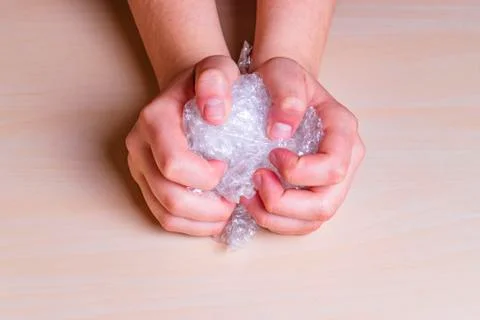 Woman's hands pressing hard on a bubble paper. Stock Photos