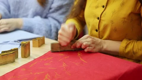 Woman's hands prints a pattern on a fabric with acrylic paint using stamps Stock Footage 170478576