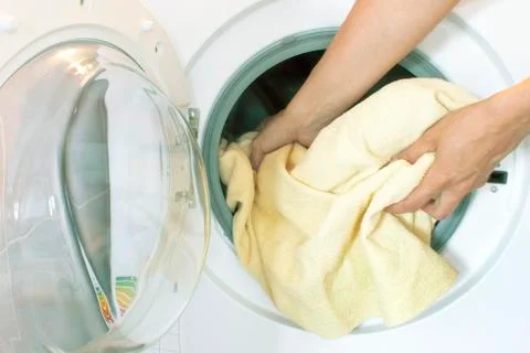 Womans hands pull the laundry out of or load the washing machine Stock Photos