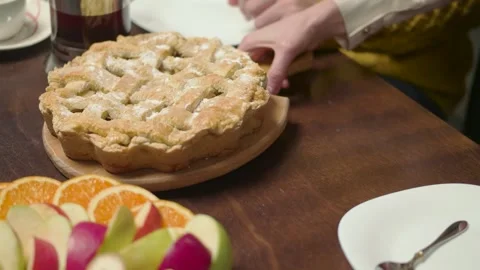 Woman's hands put a delicious pie on the dinner table Stock Footage 260335172