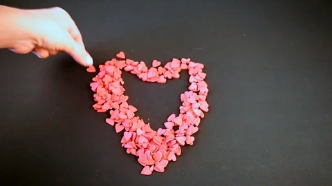 Woman's hands put heart-shaped red candy... | Stock Video | Pond5