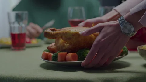 A woman's hands put a plate of baked chicken on the table. Stock Footage 256086100