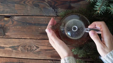 Woman's hands put a pot with hot tea on a wooden table Stock Footage 140808438