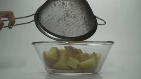 Woman's hands put a potato into a clear glass bowl Stock Footage 133700664