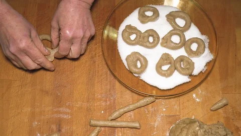 Woman's hands rolling the dough to make donuts and putting them in the sugar Stock Footage 127831668