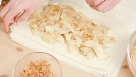 Woman's hands rolling phyllo dough to make Viennese strudel Stock Footage 121344509