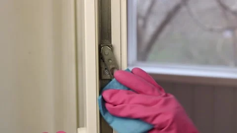 Womans hands with rubber gloves cleans the latch lock window close up. 스톡 동영상 153143655