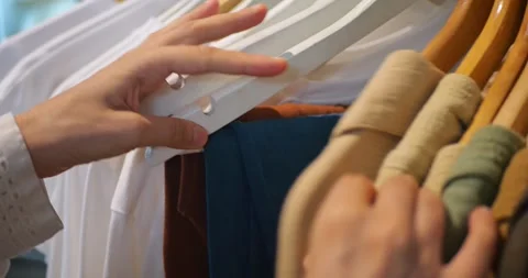 A Woman’s Hands Select Blouses and T-Shirts From a Rack at a Clothing Store Stockbeeldmateriaal 286427152