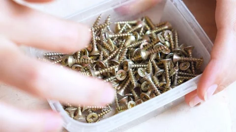 Woman's hands selecting screws from a box Stock Footage 323949603