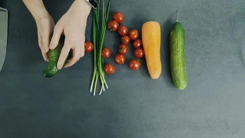 Woman's hands separate two halves of avocado and put it on the table with one Stock Footage 136114085