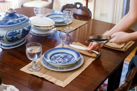 Woman's hands setting table with antique tableware Stock Photos