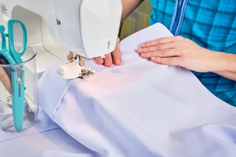 Woman's hands sew on a sewing machine close up Stock Photos