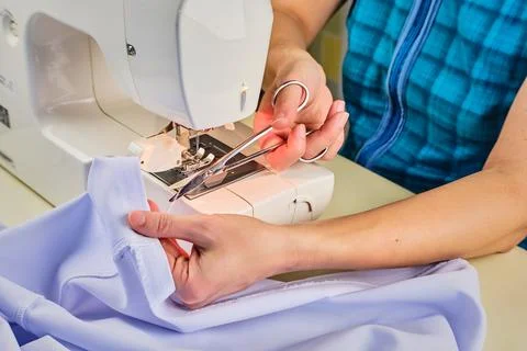 Woman's hands sew on a sewing machine close up Stock Photos