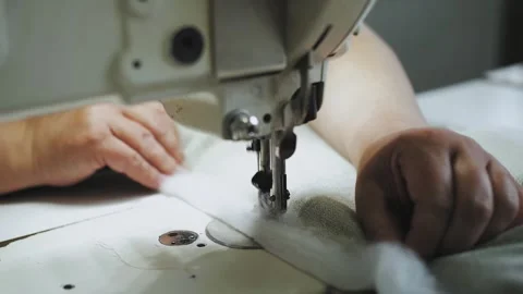 Woman's hands sewing fabric on the automatic sewing machine. Close-up seamstress Stock Footage 247079917